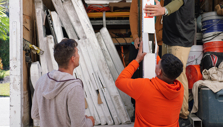 Unloading white packaged materials from a work truck filled with tools and equipment